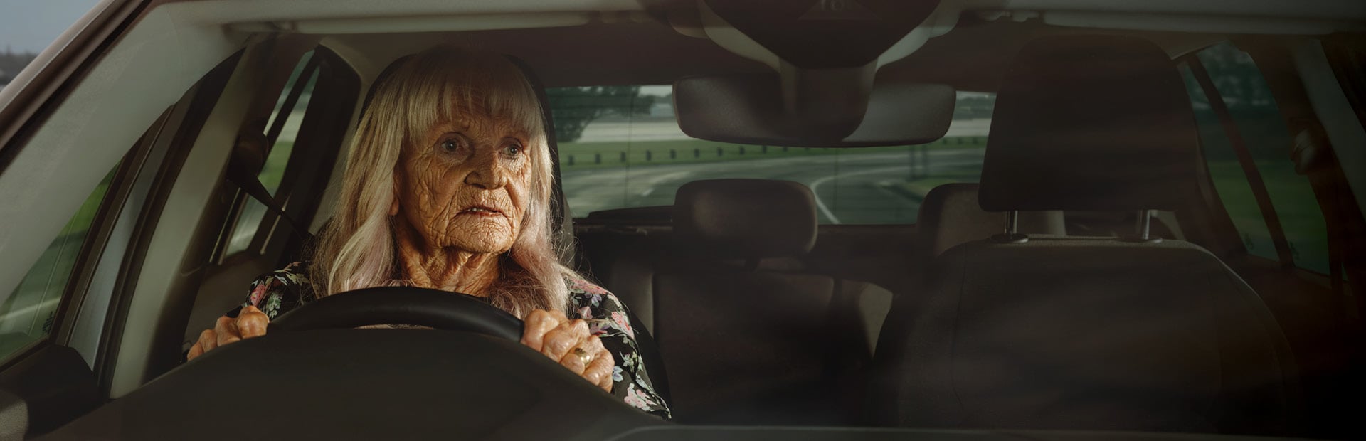 Dawn, an older woman, at the wheel of her car