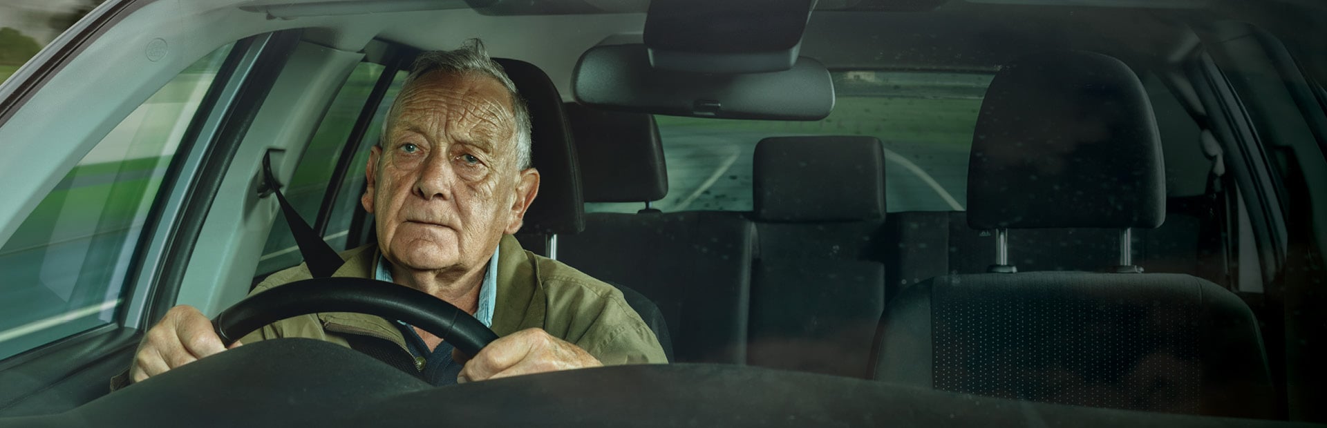 Peter, an older man, at the wheel of his car